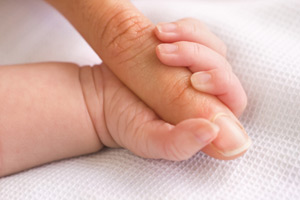 photo of baby holding mother's hand